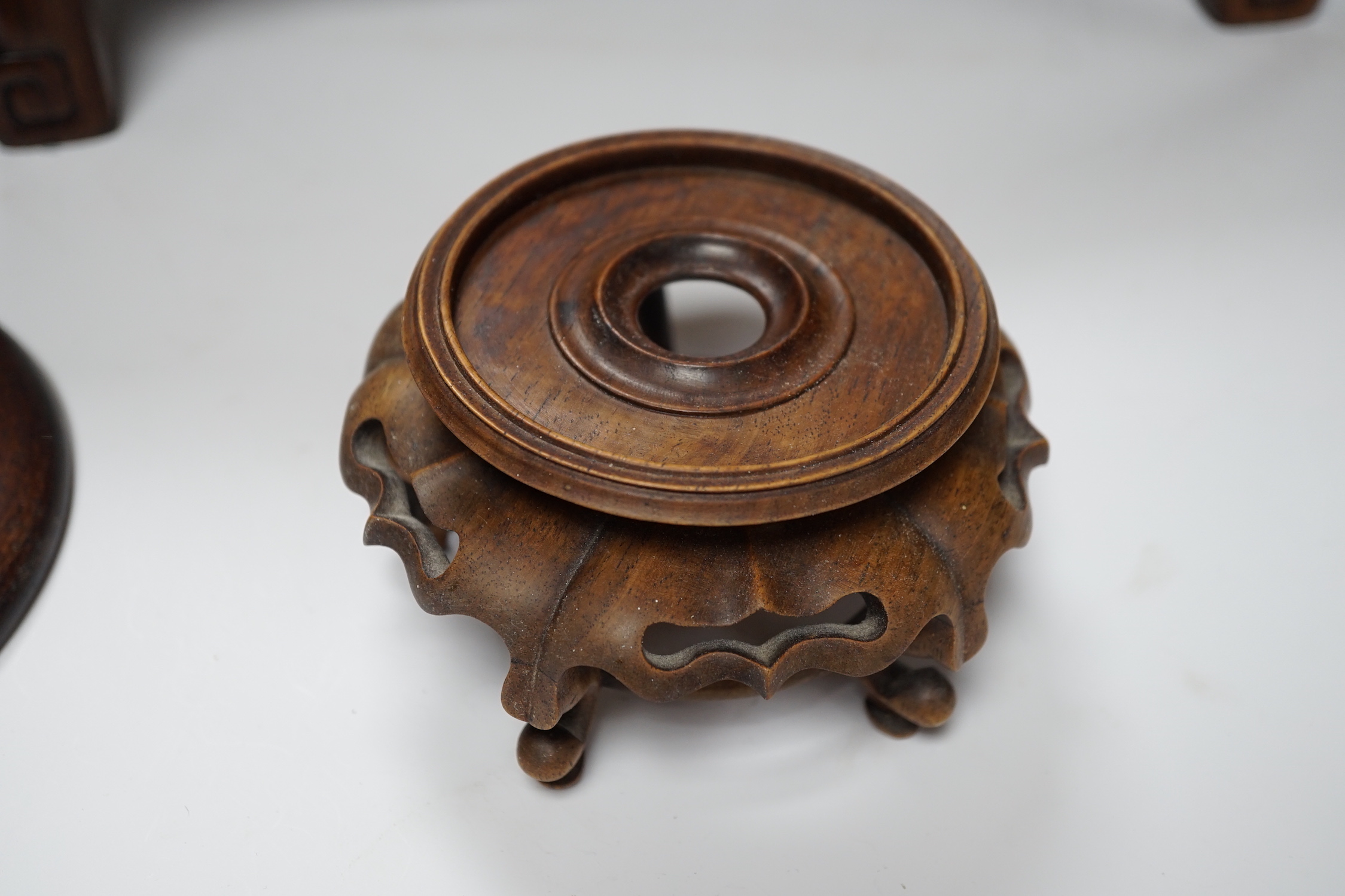 Nine Chinese hardwood vase stands, two hardwood covers and a Chinese hongmu table shaped stand, table 39cm x 25cm x 16.5cm